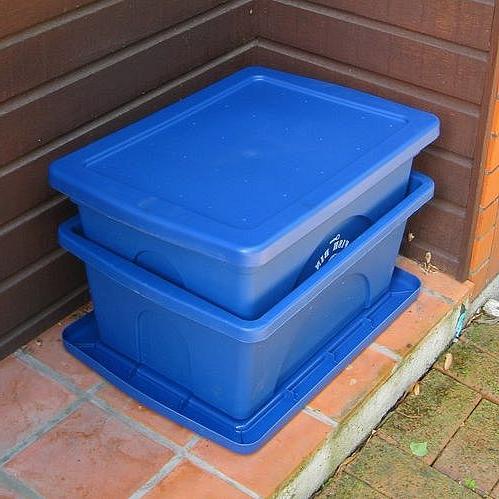Two blue plastic bins stacked with one inside the other.